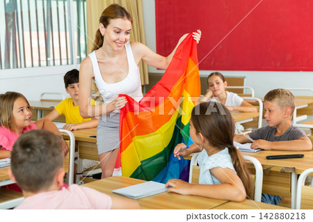 Positive female teacher standing with lgbt flag Positive female teacher standing with lgbt flag 142880218