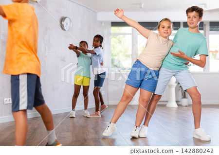 Active preteen children practicing Ballroom dances in pairs in training hall Active preteen children practicing Ballroom dances in pairs in training hall 142880242