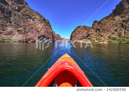 Kayak on Colorado River with Rocky Cliffs and Clear Blue Sky Adventure Perspective 142880396