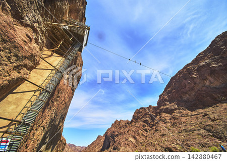 Gauging Station and Cable Tramway in Desert Canyon with Birds Under Blue Sky Gauging Station and Cable Tramway in Desert Canyon with Birds Under Blue Sky 142880467