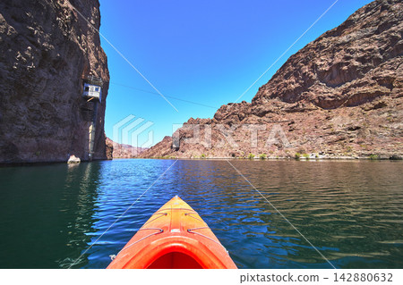 Kayak on Colorado River with Rocky Canyon Walls and Gauging Station Tramway Arizona Kayak on Colorado River with Rocky Canyon Walls and Gauging Station Tramway Arizona 142880632
