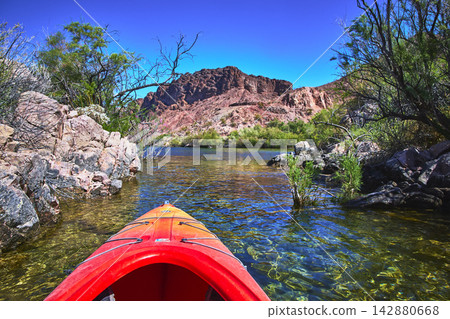 Kayak Adventure on Clear Colorado River with Rocky Desert Landscape and Blue Sky Kayak Adventure on Clear Colorado River with Rocky Desert Landscape and Blue Sky 142880668