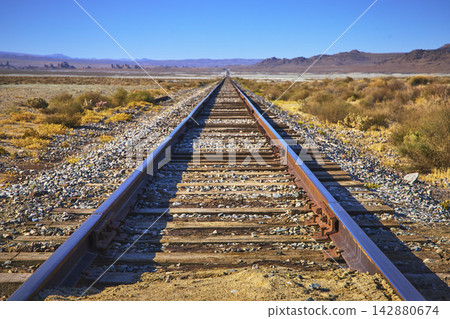 Train Track Leading to Trona Pinnacles in California Desert Landscape 142880674