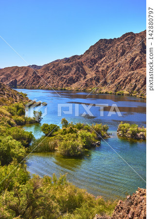 Colorado River Flowing Through Desert Landscape With Lush Green Vegetation Colorado River Flowing Through Desert Landscape With Lush Green Vegetation 142880797