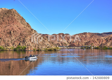 Boat on Colorado River with Desert Mountains and Clear Blue Sky Boat on Colorado River with Desert Mountains and Clear Blue Sky 142880809