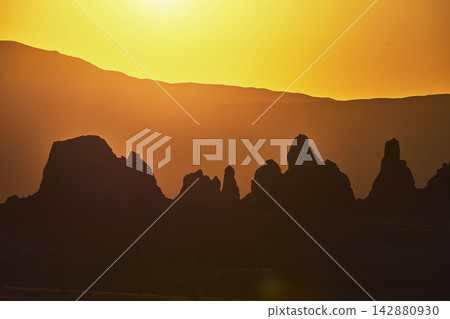 Trona Pinnacles Silhouette at Golden Hour with Mountains and Dramatic Sunlight Trona Pinnacles Silhouette at Golden Hour with Mountains and Dramatic Sunlight 142880930