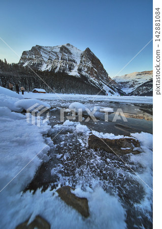 Frozen Lake and Snow Covered Mountains with Winter Forest at Lake Louise Alberta Frozen Lake and Snow Covered Mountains with Winter Forest at Lake Louise Alberta 142881084