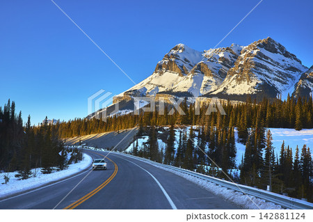 Winter Highway Driving Through Snow Forest and Rocky Mountains Winter Highway Driving Through Snow Forest and Rocky Mountains 142881124