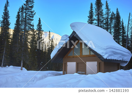 Snow Covered Cabin Winter Forest and Mountain in Banff Alberta Snow Covered Cabin Winter Forest and Mountain in Banff Alberta 142881193