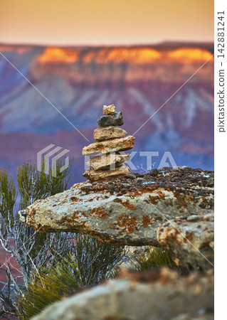 Rock Stack Cairn at Sunrise with Grand Canyon Layers and Desert Vegetation 142881241