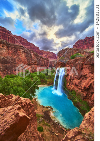 Havasu Falls Waterfall with Blue Pool and Red Canyon Walls in Lush Arizona Landscape Havasu Falls Waterfall with Blue Pool and Red Canyon Walls in Lush Arizona Landscape 142881331
