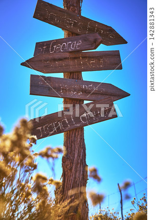 Rustic Wooden Signpost with Grand Canyon and St George Directions Under Blue Sky Rustic Wooden Signpost with Grand Canyon and St George Directions Under Blue Sky 142881343