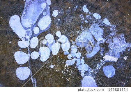 Frozen Methane Bubbles and Cracks in Winter Ice Close Up on Lake Surface Frozen Methane Bubbles and Cracks in Winter Ice Close Up on Lake Surface 142881354