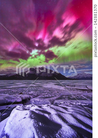 Northern Lights Over Frozen Lake and Snowy Mountains Winter Night Sky Northern Lights Over Frozen Lake and Snowy Mountains Winter Night Sky 142881370