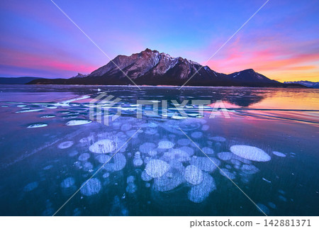 Frozen Methane Ice Bubbles Sunset Reflection and Winter Mountains Landscape 142881371