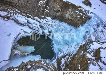 Top Down Frozen Waterfall Ice Pool and Rocky Canyon in Winter Top Down Frozen Waterfall Ice Pool and Rocky Canyon in Winter 142881486