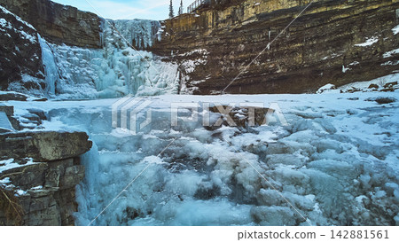Frozen Waterfall Winter Landscape with Rugged Cliffs and Ice Formations Frozen Waterfall Winter Landscape with Rugged Cliffs and Ice Formations 142881561