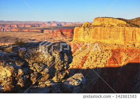 Sunrise Light on Rocky Foreground and Colorful Canyon Walls at Grand Canyon Overlook Sunrise Light on Rocky Foreground and Colorful Canyon Walls at Grand Canyon Overlook 142881583