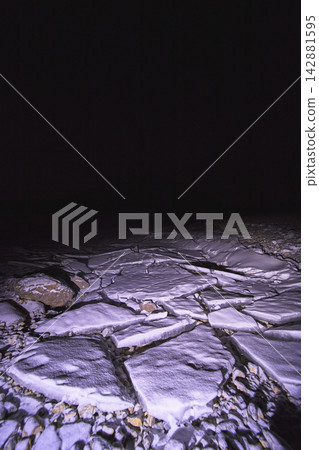 Winter Night Broken Ice Slabs and Snow on Frozen Lake Surface 142881595