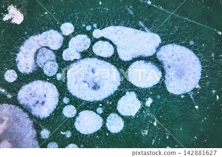 Frozen Methane Ice Bubbles Texture on Winter Lake Surface Close Up Frozen Methane Ice Bubbles Texture on Winter Lake Surface Close Up 142881627