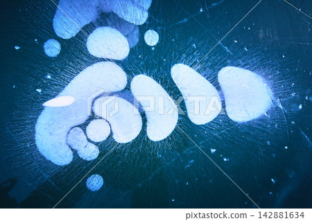Frozen Methane Bubbles Under Ice on Winter Lake Surface with Blue Abstract Patterns Frozen Methane Bubbles Under Ice on Winter Lake Surface with Blue Abstract Patterns 142881634