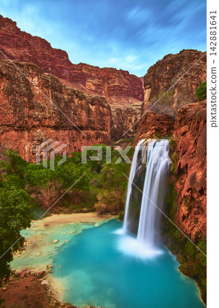 Havasu Falls Waterfall and Turquoise Pool Among Red Cliffs in Arizona Canyon Havasu Falls Waterfall and Turquoise Pool Among Red Cliffs in Arizona Canyon 142881641