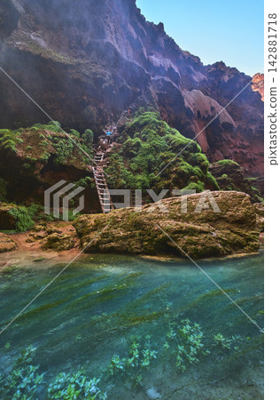 Havasupai Mooney Falls Trail Ladder and Chains Beside Turquoise Pool and Mossy Cliffs Havasupai Mooney Falls Trail Ladder and Chains Beside Turquoise Pool and Mossy Cliffs 142881718