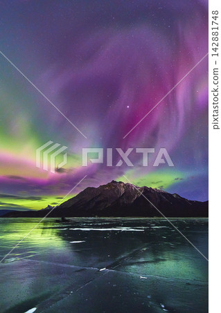 Northern Lights Over Frozen Lake and Mountain Winter Night in Alberta Northern Lights Over Frozen Lake and Mountain Winter Night in Alberta 142881748