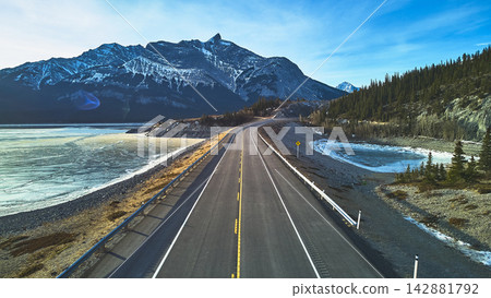 Aerial Frozen Lake Mountain Road and Pine Forest with Winter Landscape Aerial Frozen Lake Mountain Road and Pine Forest with Winter Landscape 142881792