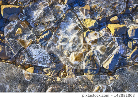 Frozen Lake Ice Shards and Rocky Shore Texture in Winter Frozen Lake Ice Shards and Rocky Shore Texture in Winter 142881808