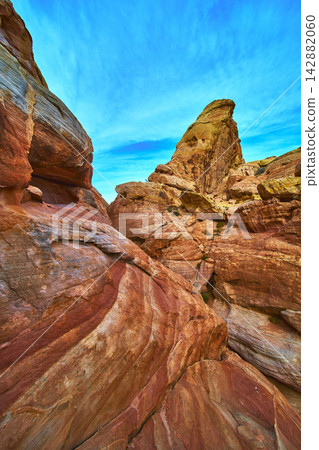 Colorful Sandstone Formations and Dramatic Pinnacle Under Vibrant Blue Sky 142882060