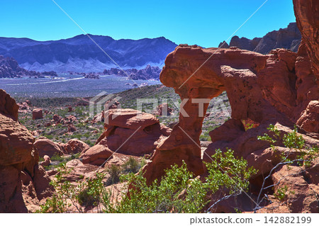 Red Sandstone Arch Valley of Fire Desert Landscape and Distant Mountains Red Sandstone Arch Valley of Fire Desert Landscape and Distant Mountains 142882199