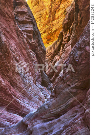 Colorful Sandstone Slot Canyon Walls with Sunlit Layers and Deep Shadows Colorful Sandstone Slot Canyon Walls with Sunlit Layers and Deep Shadows 142882248
