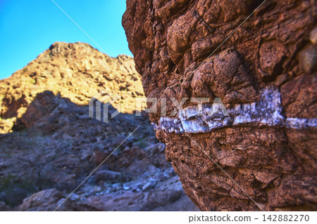 Close Up Red Rock Formation with White Gem Vein in Sunlit Desert Landscape Close Up Red Rock Formation with White Gem Vein in Sunlit Desert Landscape 142882270