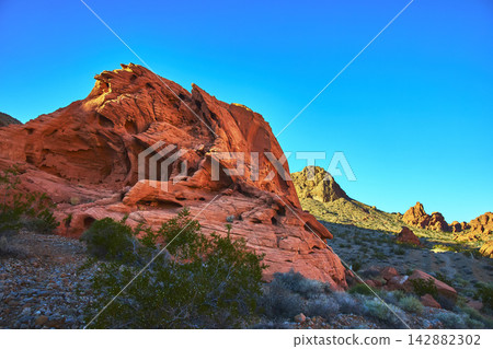 Red Sandstone Formation and Desert Landscape Under Vibrant Blue Sky Red Sandstone Formation and Desert Landscape Under Vibrant Blue Sky 142882302
