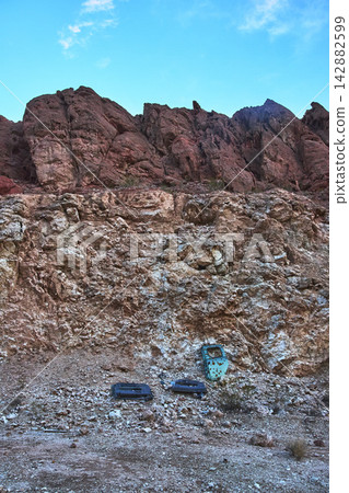 Desert Rock Formation with Abandoned Car Door and Shooting Range Remnants Desert Rock Formation with Abandoned Car Door and Shooting Range Remnants 142882599