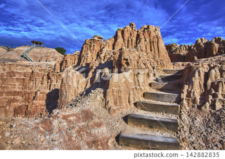 Cathedral Gorge State Park Canyon Formations and Wooden Stairs Under Blue Sky Cathedral Gorge State Park Canyon Formations and Wooden Stairs Under Blue Sky 142882835