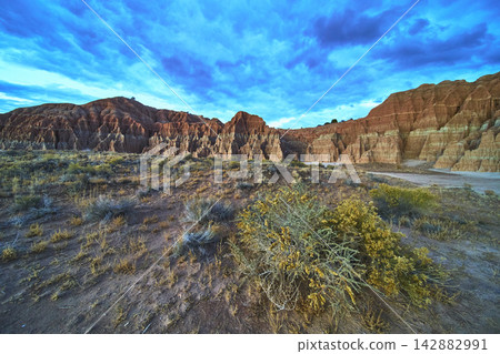 Cathedral Gorge State Park Red Rock Formations and Desert Vegetation Under Vibrant Sky 142882991