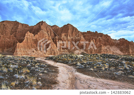 Cathedral Gorge Red Rock Formations and Desert Trail Under Dramatic Blue Sky Cathedral Gorge Red Rock Formations and Desert Trail Under Dramatic Blue Sky 142883062