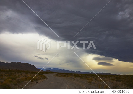 Storm Clouds Over Desert Road and Mountains Nevada United States Storm Clouds Over Desert Road and Mountains Nevada United States 142883092