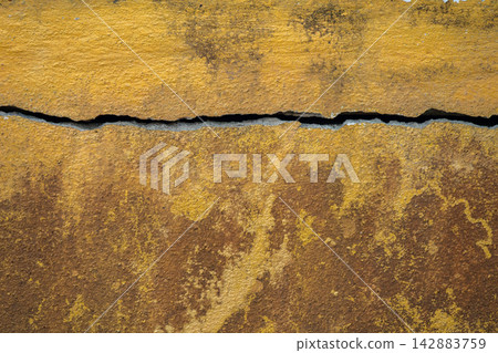 Full frame shot of cracked and dirty yellow wall. Wider cracks often represent serious structural damage and can cause serious issues. Full frame shot of cracked and dirty yellow wall. Wider cracks often represent serious structural damage and can cause serious issues. 142883759