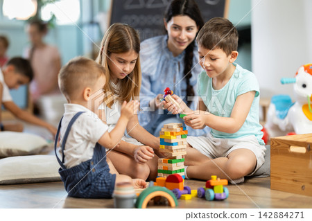 Group of children playing with various toys in kindergarten Group of children playing with various toys in kindergarten 142884271