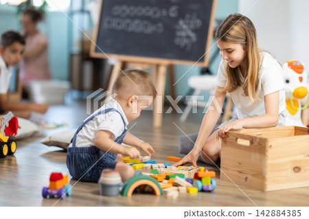 Childrens leisure, supervised children, children playing in living room of kindergarten. Childrens leisure, supervised children, children playing in living room of kindergarten. 142884385