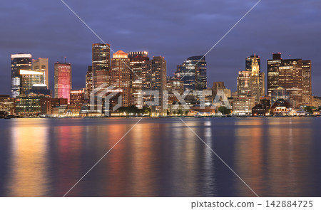 Boston skyline illuminated at dusk with Atlantic Ocean on the foreground, USA Boston skyline illuminated at dusk with Atlantic Ocean on the foreground, USA 142884725
