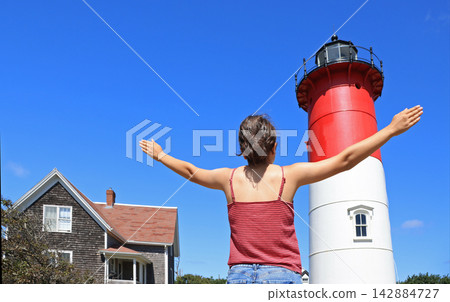 Teenager girl enjoying the view of Nauset Lighthouse in Cape Cod, Massachusetts, USA Teenager girl enjoying the view of Nauset Lighthouse in Cape Cod, Massachusetts, USA 142884727