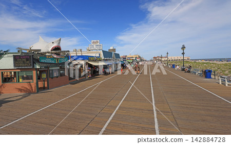 Tourists enjoying Ocean City wooden boarder walk, Atlantic Ocean, USA Tourists enjoying Ocean City wooden boarder walk, Atlantic Ocean, USA 142884728