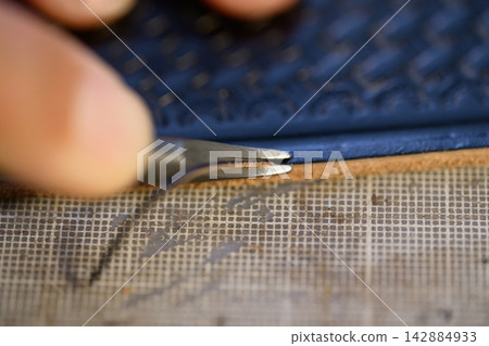 工匠正在處理皮帶的邊緣。 142884933