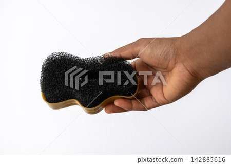 Person holding footwear polish sponge applicator isolated on white background. Ideal concept for leather shoe maintenance, cleaning equipment, and quick shine. Person holding footwear polish sponge applicator isolated on white background. Ideal concept for leather shoe maintenance, cleaning equipment, and quick shine. 142885616