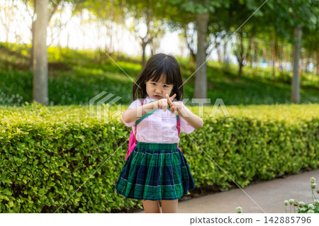Asian Little Girl Making No or Stop Gesture with Crossed Fingers Outdoors Asian Little Girl Making No or Stop Gesture with Crossed Fingers Outdoors 142885796