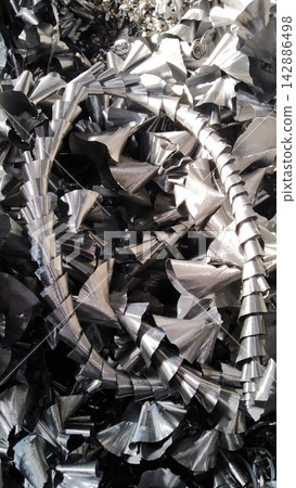 Steel scrap materials recycling. Aluminum chip waste after machining metal parts on a cnc lathe. Closeup twisted spiral steel shavings. Small roughness sharpness, Steel scrap materials recycling. Aluminum chip waste after machining metal parts on a cnc lathe. Closeup twisted spiral steel shavings. Small roughness sharpness, 142886498